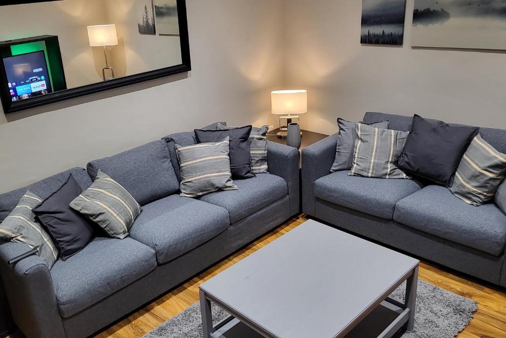 a living room with two couches and a table at Kepler Residence Modern 4 Bedroom Property 1 mile from Leeds Centre in Leeds