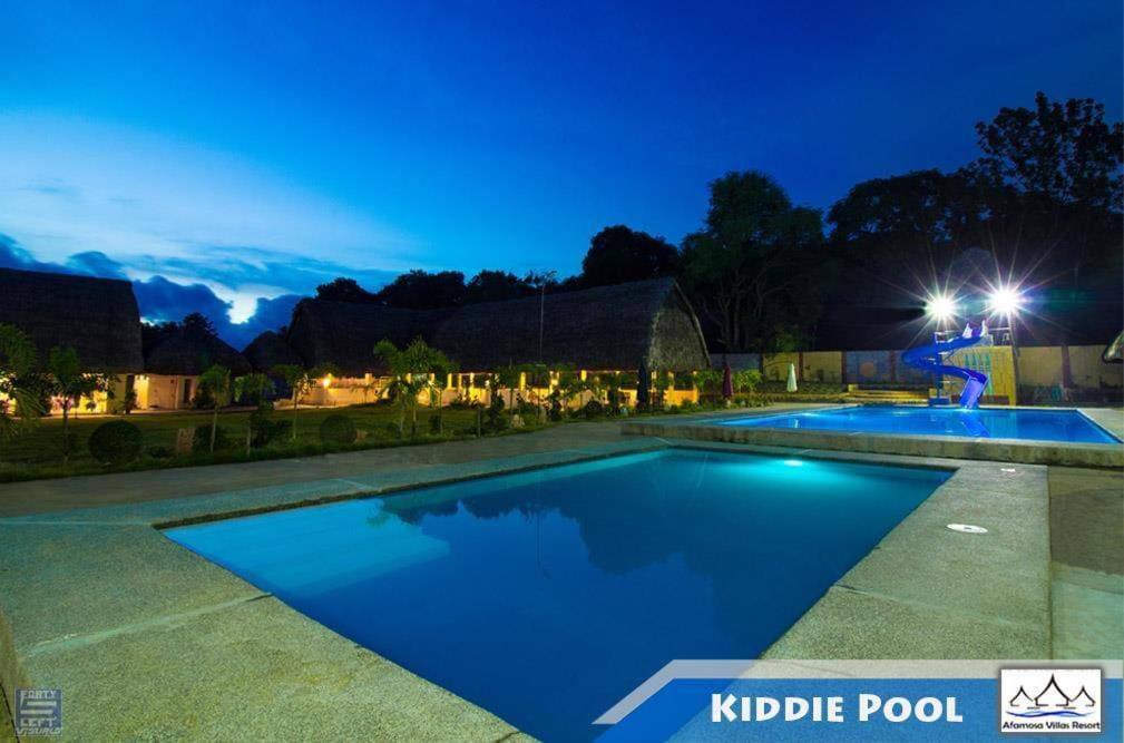 - une piscine dans un jardin la nuit dans l'établissement RedDoorz @ Afamosa Villas Resort Ilocos Sur, à Cabanglotan