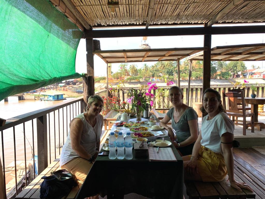 un grupo de tres personas sentadas en una mesa en ST 63 Home Stay & Tour Kampong Khleang, en Kâmpóng Khleăng