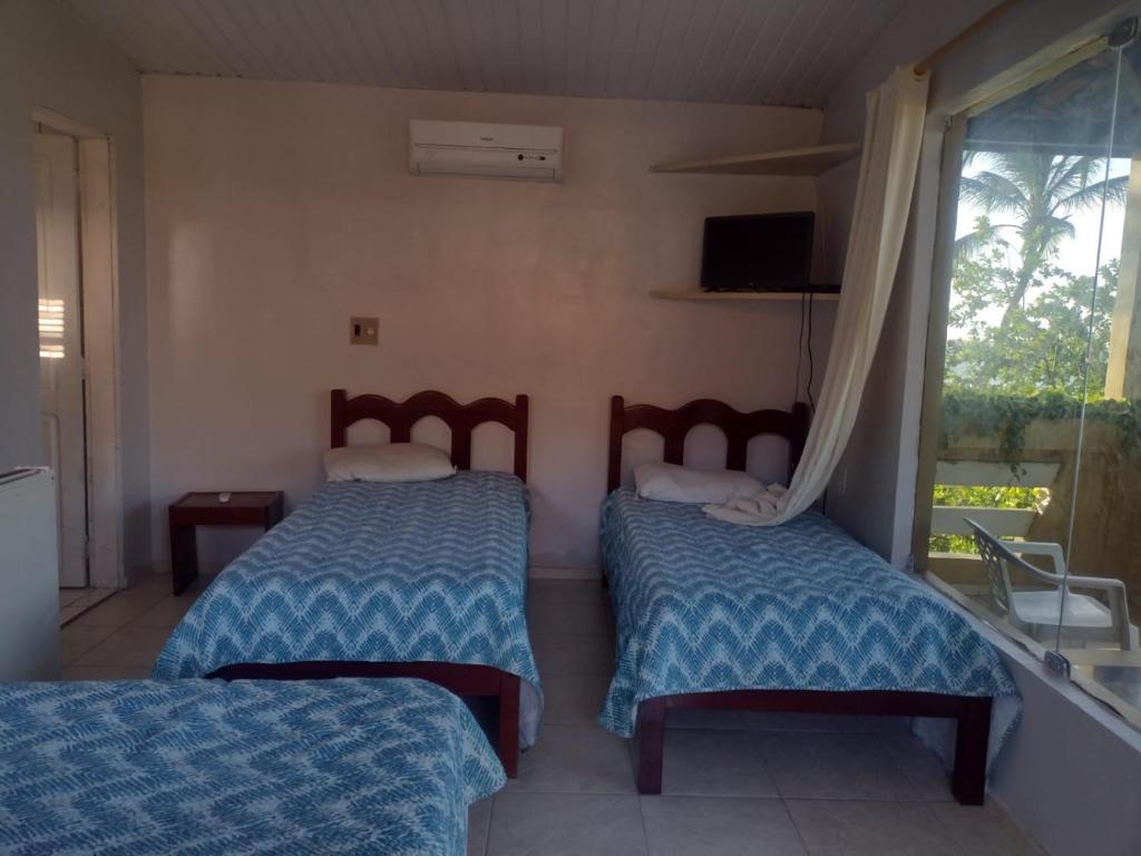 Giường trong phòng chung tại Pousada e Restaurante Sombra dos Coqueiros