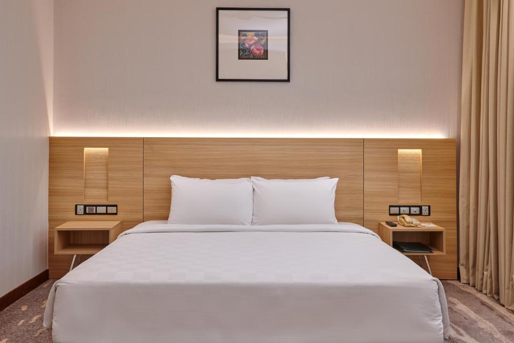 A close view of a large bed with a wood headboard and built-in bedside lighting.