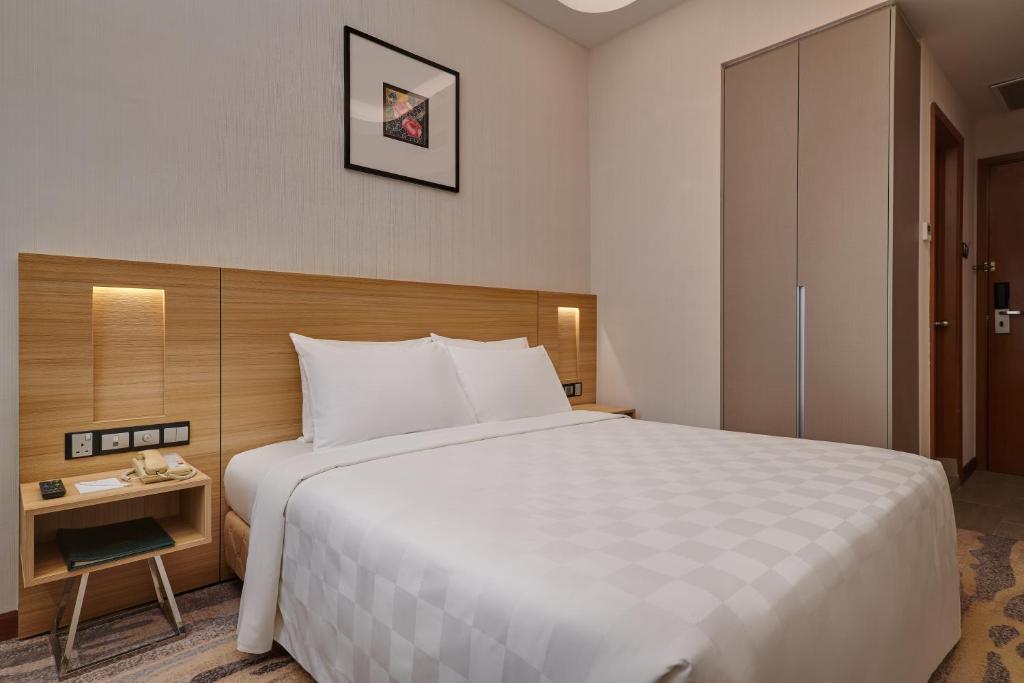A large-bed room with a bedside work surface, wardrobe and bathroom entry.