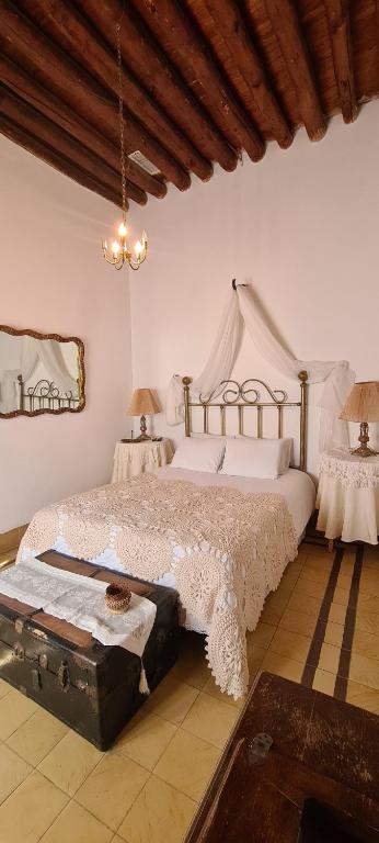 Un dormitorio con una cama grande y una lámpara de araña. en San Felipe el Real, en Chihuahua