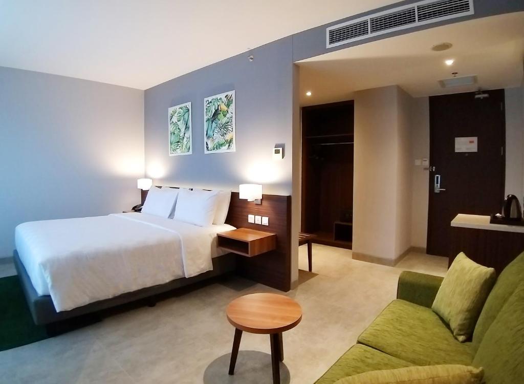 Postel nebo postele na pokoji v ubytování Swiss-Belinn Bogor