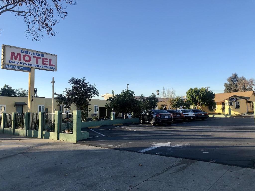 un panneau du motel devant un parking dans l'établissement Deluxe Inn, à Pomona