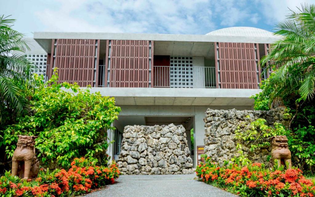 a building with a bunch of flowers in front of it at Asahinoyado Shidakaji in Nanjo