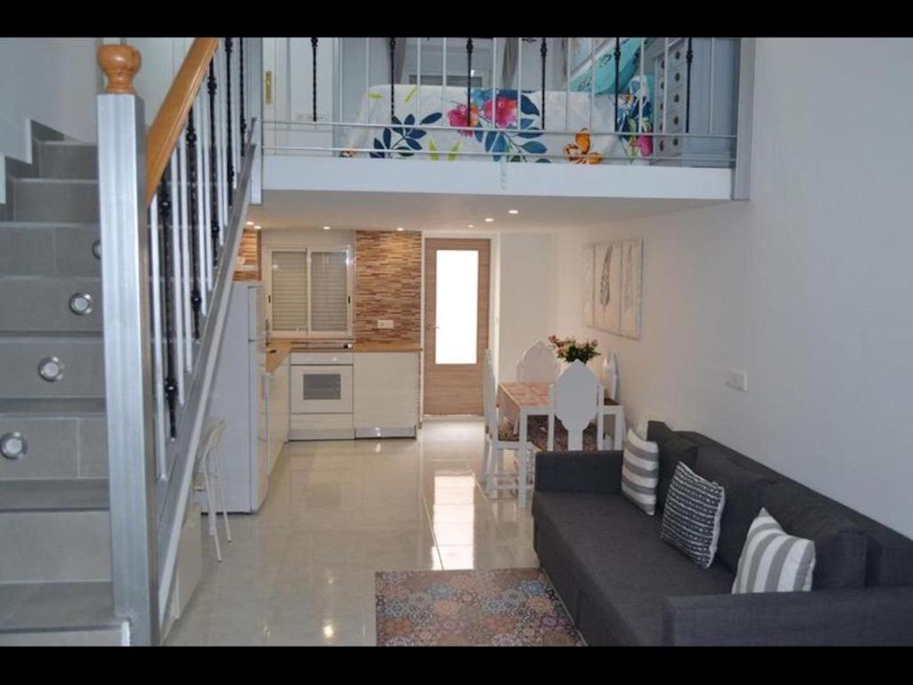 sala de estar con sofá y escalera en Stunning Loft Apartment Air conditioning, impressive modern conversion, en Alicante