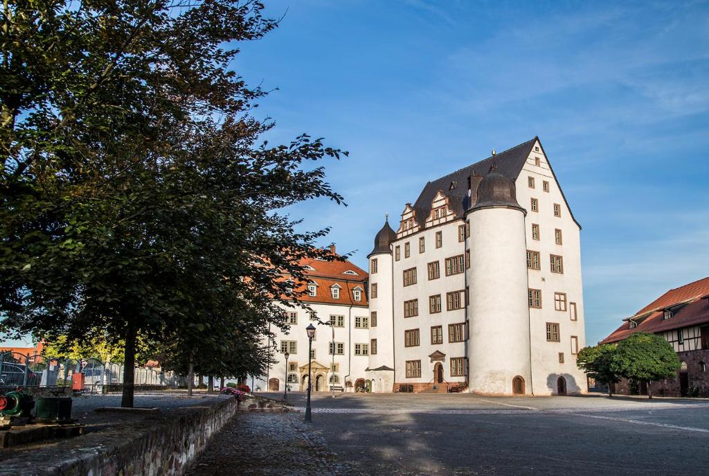 a large white building with a black roof at Pension Schloss Heringen in Heringen