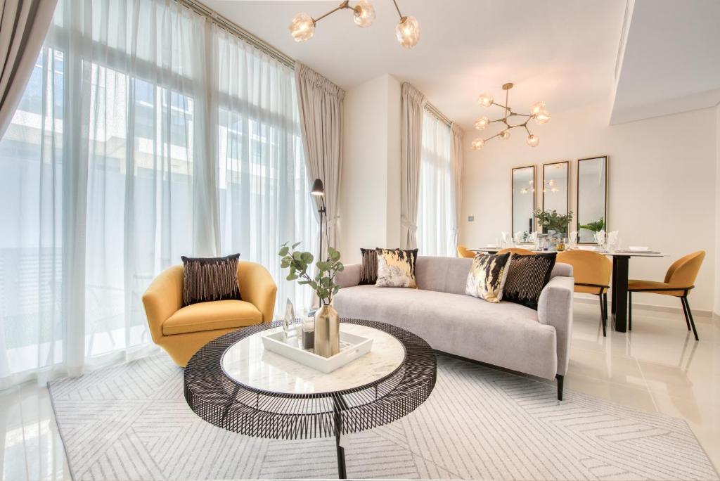 sala de estar con sofá y mesa en Charismatic 3BR Townhouse at DAMAC Hills 2 Dubailand by Deluxe Holiday Homes, en Dubái