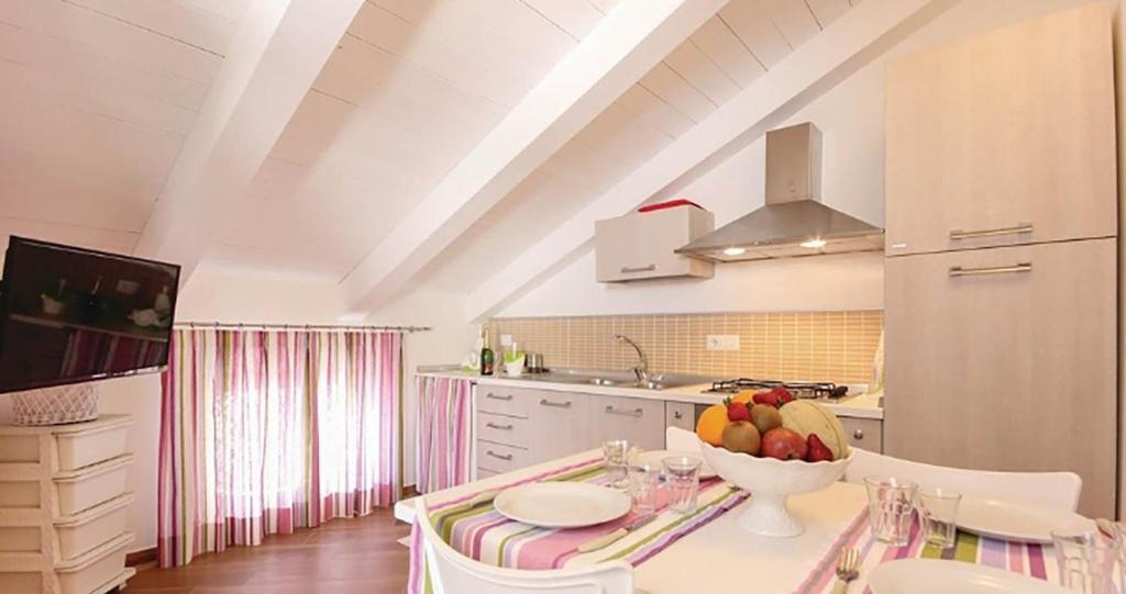 una cocina con una mesa con un bol de fruta. en Castellabate Apartments Mansarda Maddalena, en Castellabate