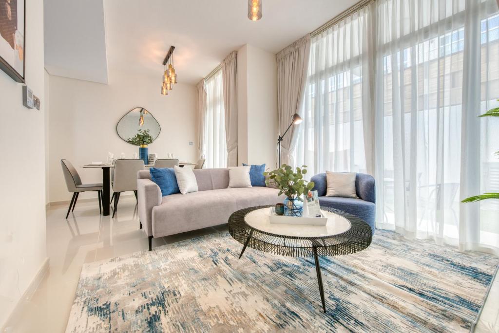 un soggiorno con divano e tavolo di Spell-binding 3BR Townhouse at DAMAC Hills 2 Dubailand by Deluxe Holiday Homes a Dubai