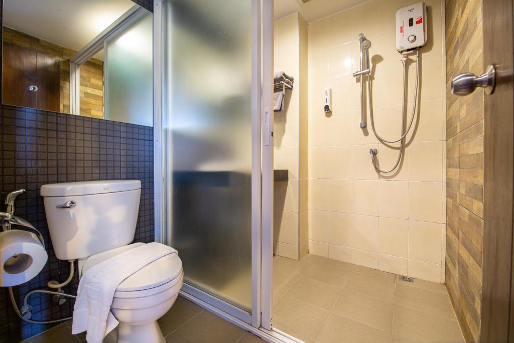 A compact bathroom with a separate shower enclosure and toilet.