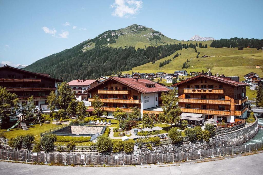 um grupo de edifícios em frente a uma montanha em Hotel Gotthard em Lech am Arlberg