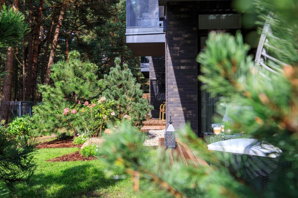a garden with christmas trees on the side of a house at Vanagupes Park Apartment, By Cohost in Palanga