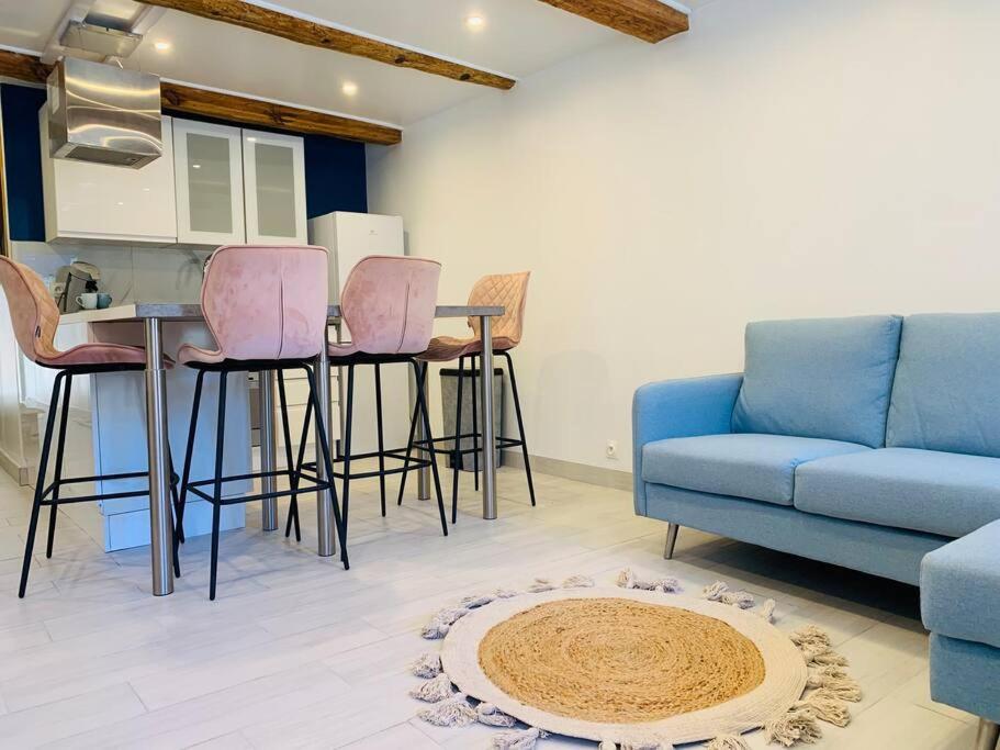 ein Wohnzimmer mit einem Sofa, einem Tisch und Stühlen in der Unterkunft Appartement cocooning pour un séjours à Tende in Tende