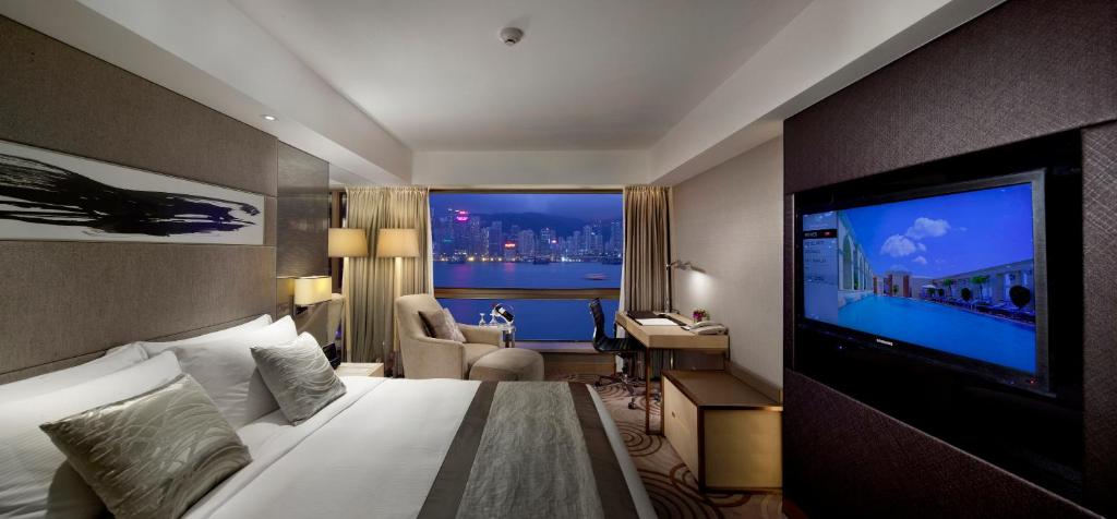 a hotel room with a bed and a flat screen tv at The Royal Garden in Hong Kong