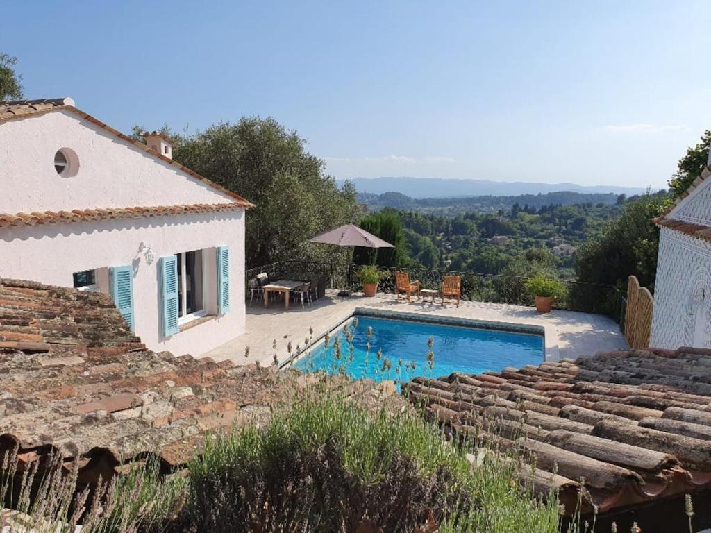 uma villa com piscina em frente a uma casa em Pool House Matisse in großem Park mit geheizten Pool em Châteauneuf