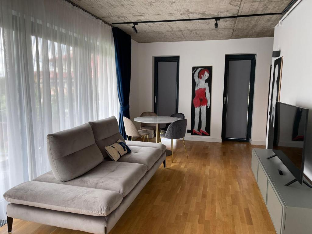 een woonkamer met een bank en een tafel bij Studio Cuzino 106 Pipera in Voluntari