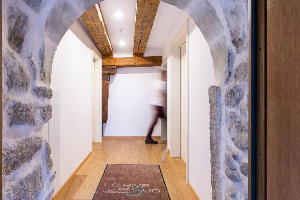 un couloir avec un mur en pierre et un tapis dans l'établissement Le Rive Sud, à Estavayer-le-Lac