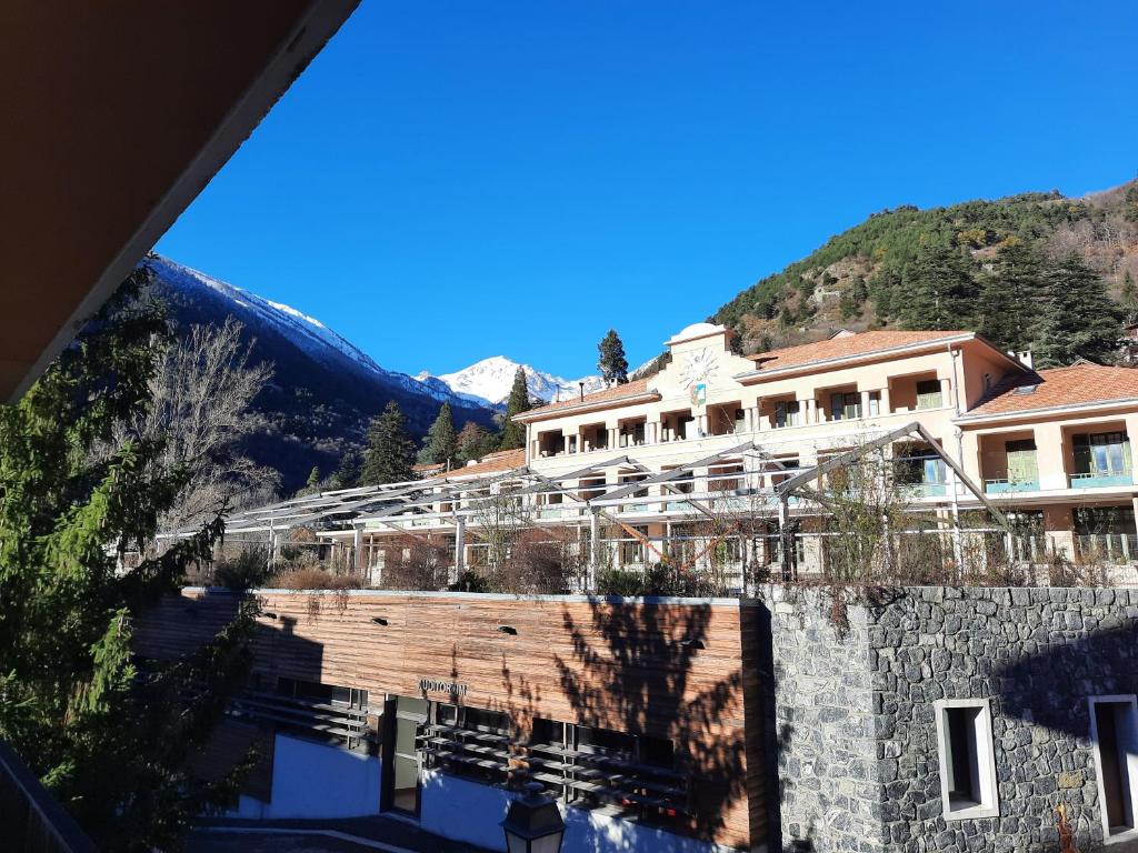 una vista de un edificio con una montaña en el fondo en Studio rénové au cœur du village, en Saint-Martin-Vésubie