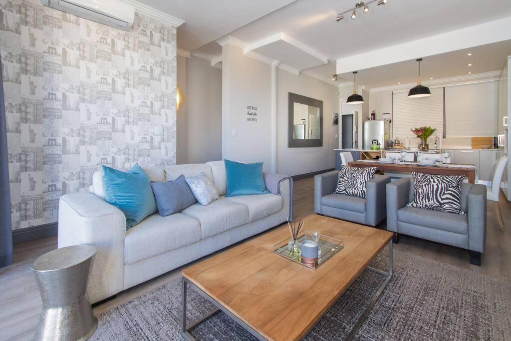 sala de estar con sofá, 2 sillas y mesa en 9 Church View - No LoadShedding - Homely Apartment, en Ciudad del Cabo