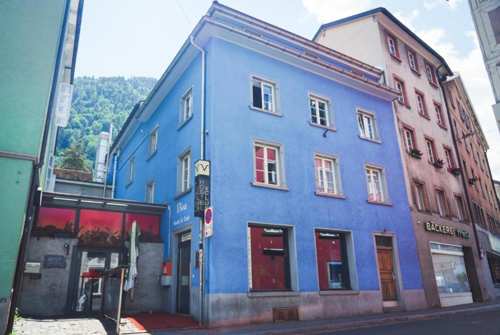 un bâtiment bleu sur le côté d'une rue dans l'établissement VIVA Hostel, à Coire