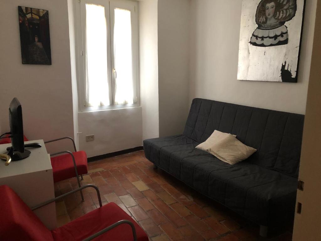 - un salon avec un canapé noir et un fauteuil rouge dans l'établissement Domus Carducci, à Pesaro