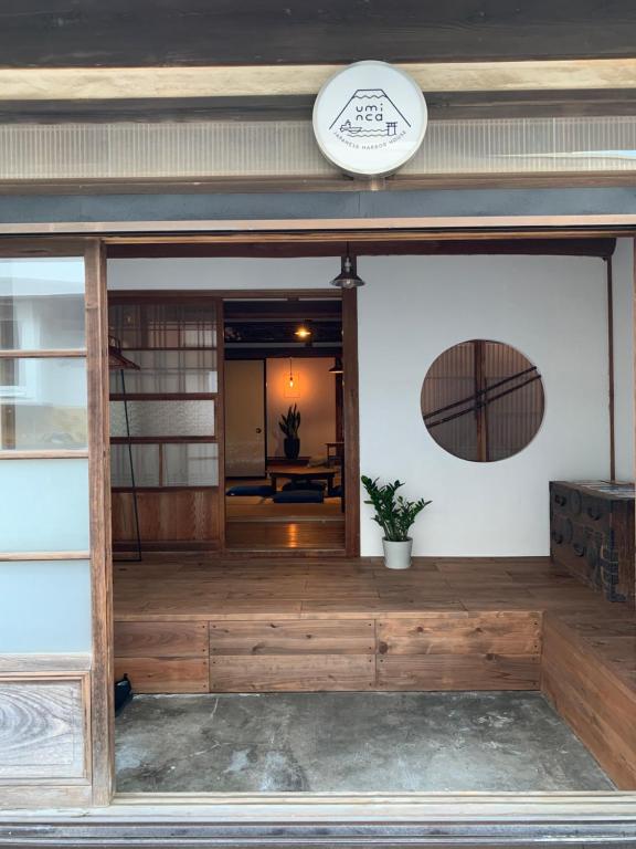 una entrada a un edificio con porche de madera en uminca ウミンカ, en Numazu