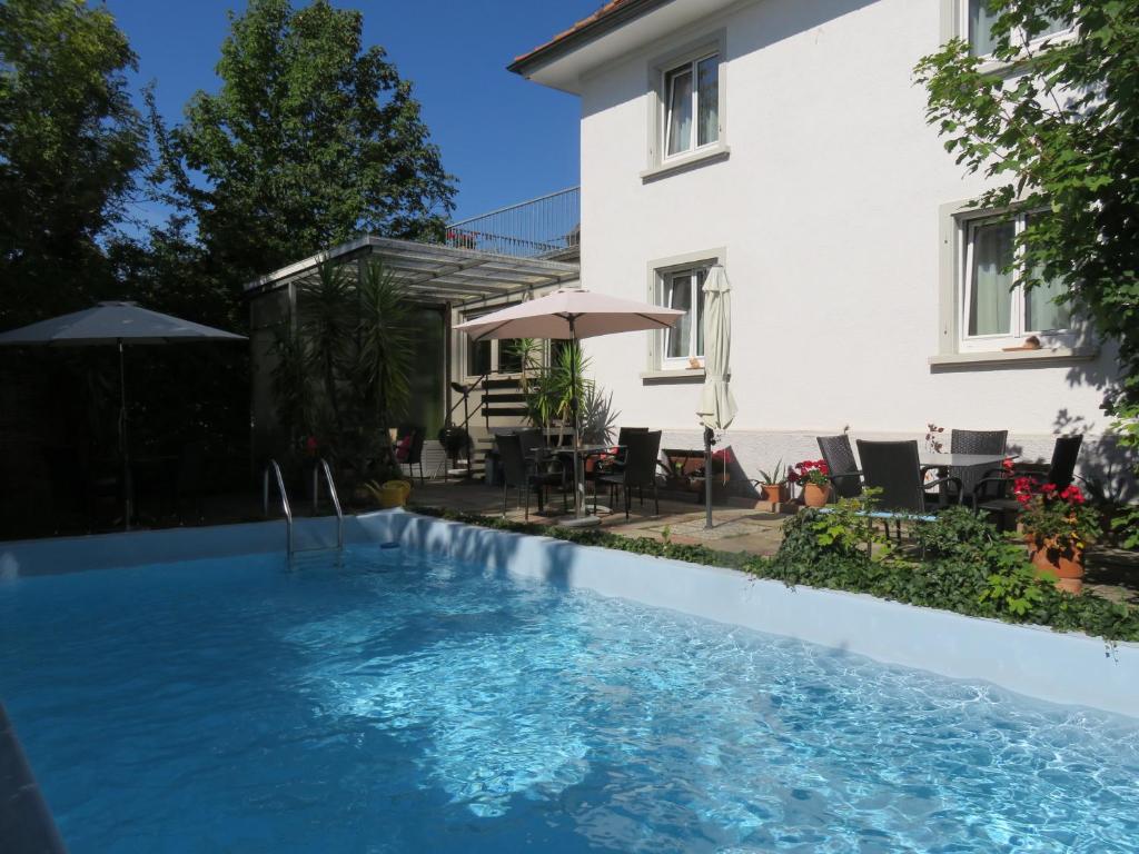 uma piscina em frente a uma casa em Pension Säntisblick em Meersburg