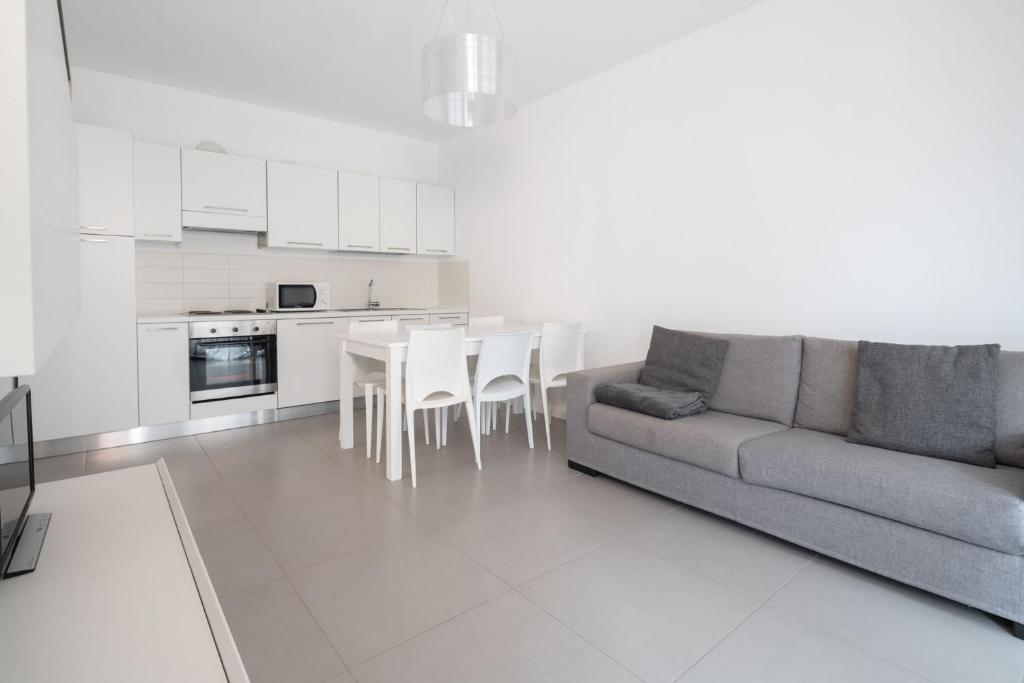 uma sala de estar com um sofá e uma cozinha em Finisterrae 2 em Lido di Jesolo