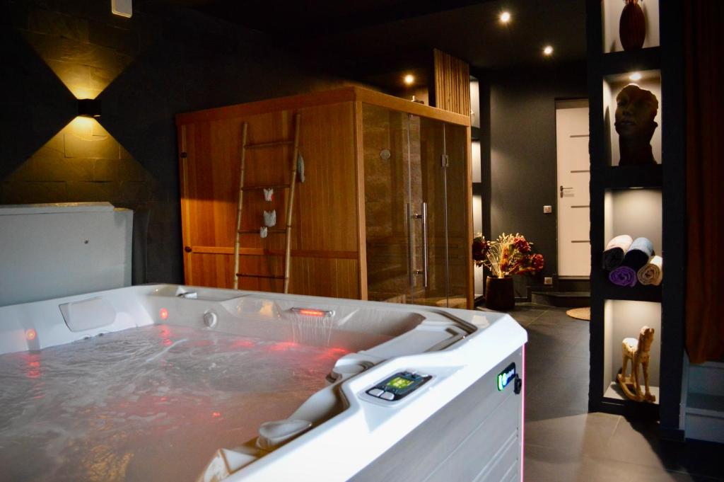 uma grande banheira cheia de água num quarto em La Charmeraie Wellness & SPA em Lacroix-Saint-Ouen