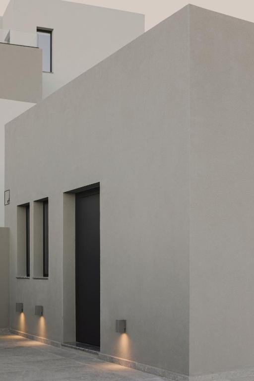 a white wall with a black door on it at Aposperia Memorable Living in Kyra Panagia