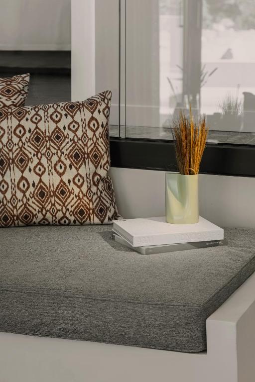 a table with a book and a pillow and a plant at Aposperia Memorable Living in Kyra Panagia