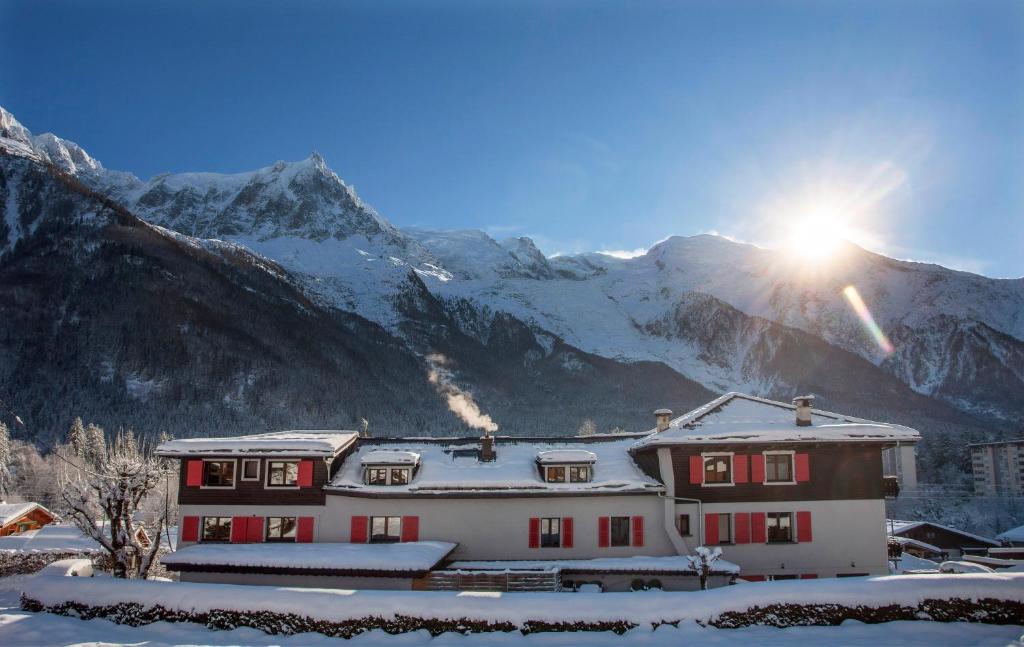 dom przed pokrytą śniegiem górą w obiekcie La Chaumière Mountain Lodge w Chamonix-Mont-Blanc