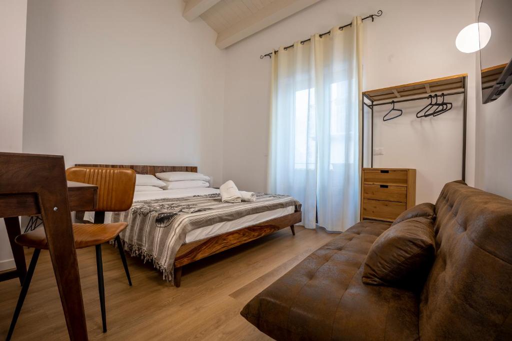 Vespri Apartments في باليرمو: غرفة معيشة مع أريكة وسرير