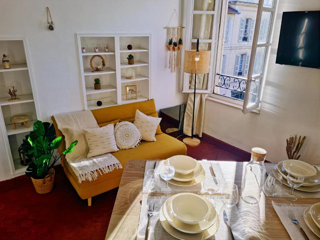 un soggiorno con tavolo e divano giallo di Charmant T3 calme au coeur du centre historique ad Avignone