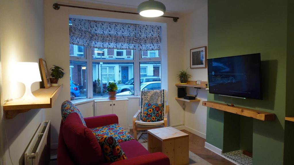 a living room with a couch and a tv and a window at Portallo Peace: a sanctuary in the city. in Belfast