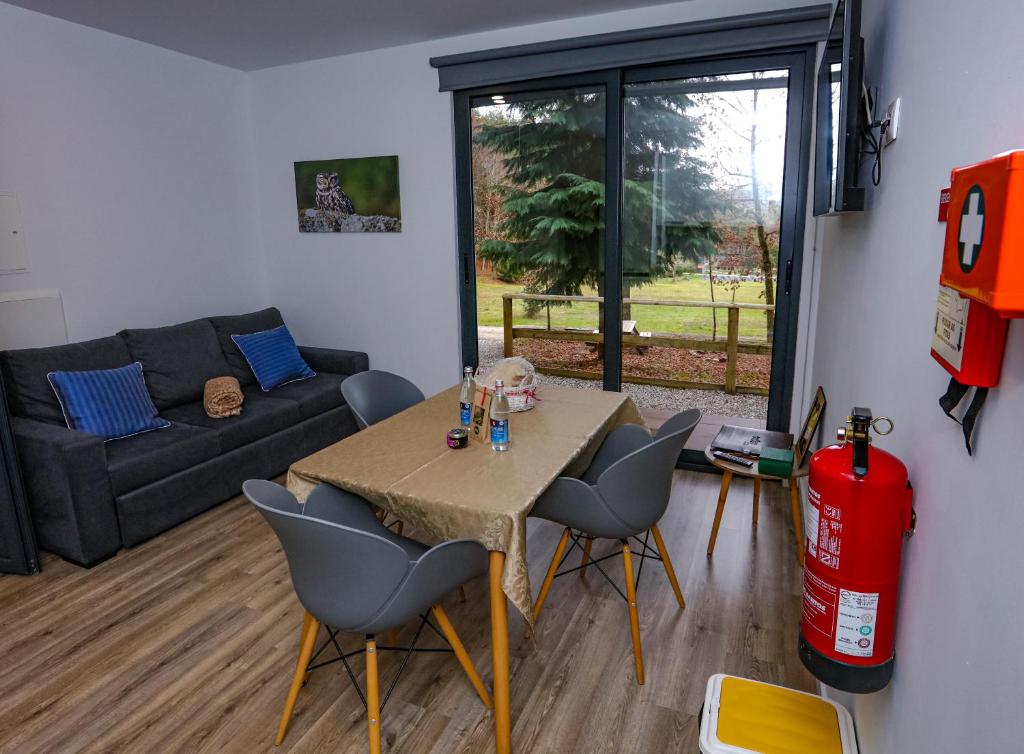 uma sala de estar com uma mesa e cadeiras e um sofá em Boticas Parque Natur Houses em Boticas