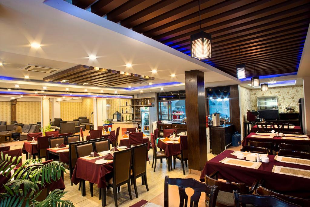 una sala da pranzo con tavoli e sedie in un ristorante di The Address Kathmandu Hotel a Kathmandu