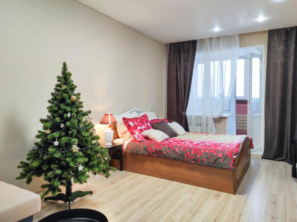 ヨシュカル・オラにあるСеть ЙоХоум Apartment on Petrova 30の寝室のクリスマスツリーとクリスマスツリーサイド付
