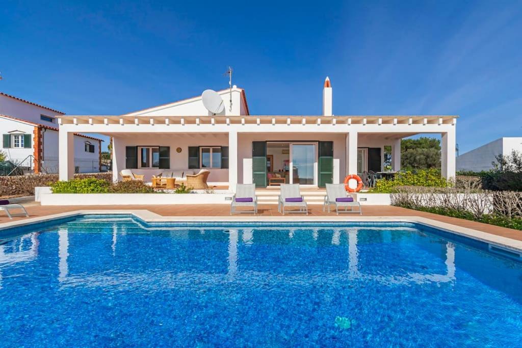 a villa with a swimming pool in front of a house at Villa Casa Nova in Sant Lluis