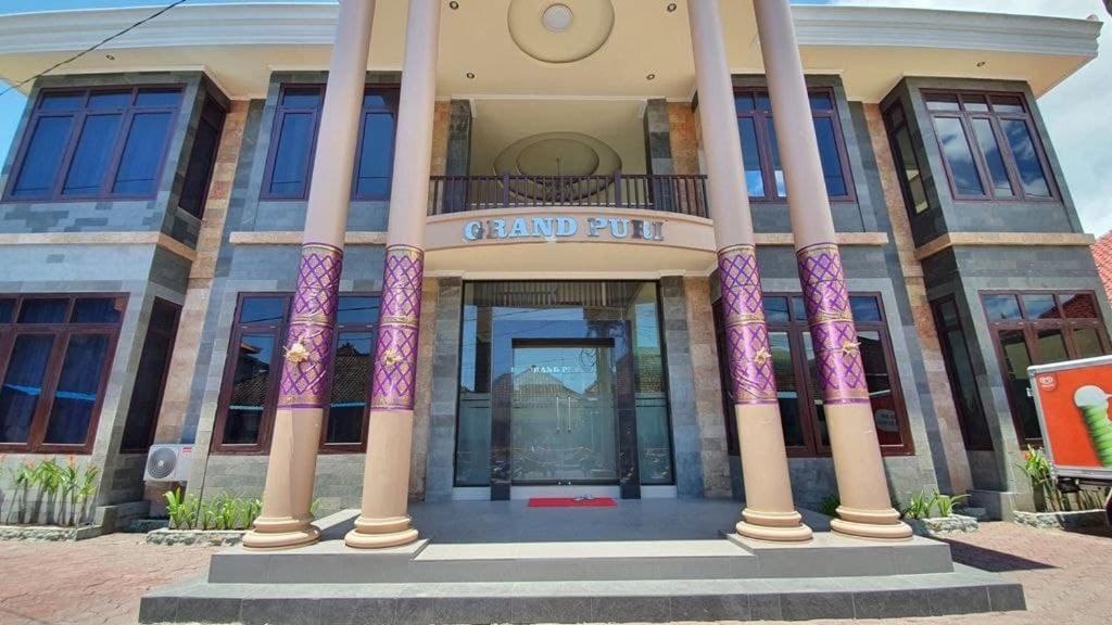 a grand put building with columns in front of it at Grand Puri Hotel in Nusa Penida