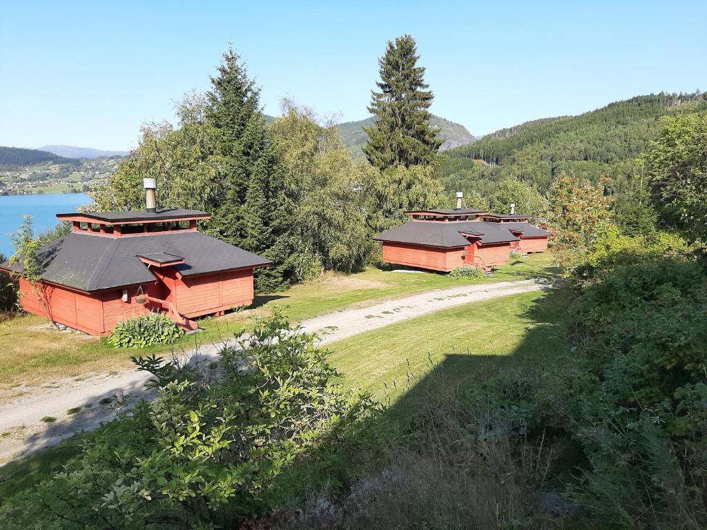 due cabine rosse su una collina vicino a un lago di Kvamshaugen hytter a Luster