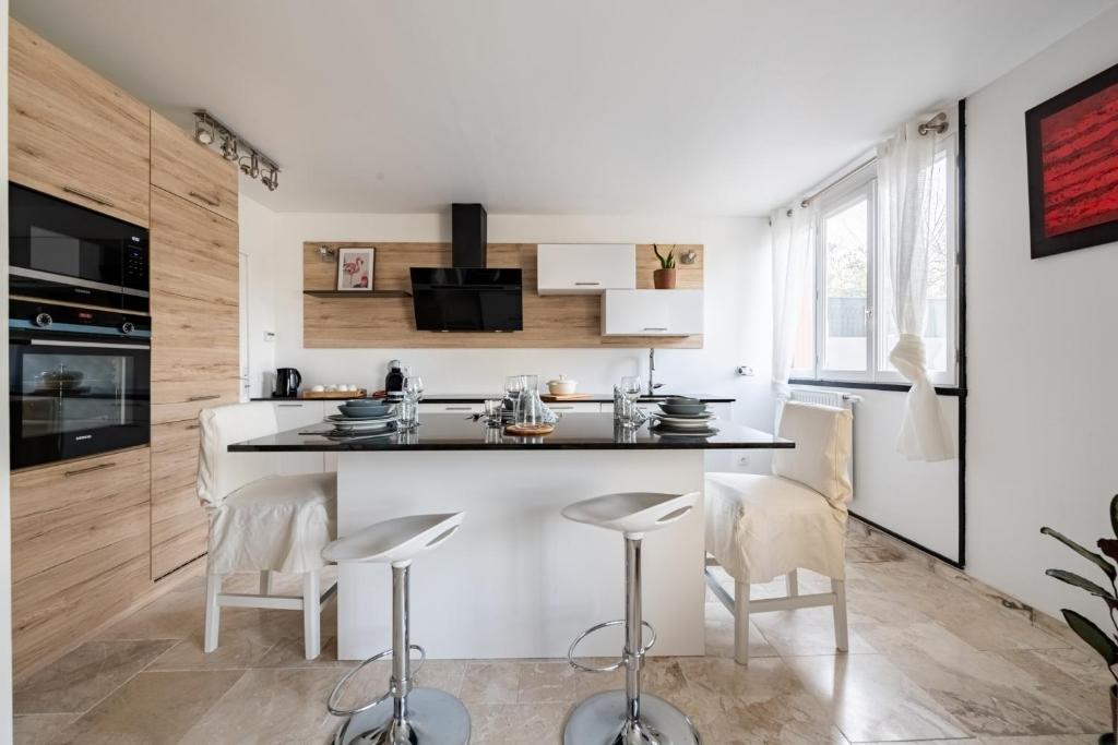 a kitchen with a counter and stools in a room at L&#39;Impressionniste in Pontoise