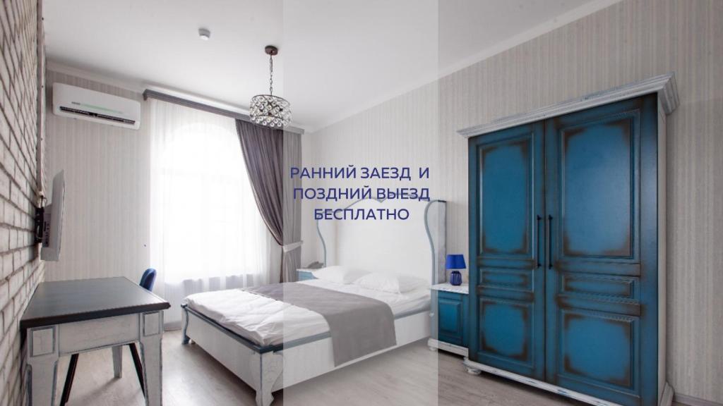 ein Schlafzimmer mit einem Bett und einer blauen Tür in der Unterkunft Abbey Road Hotel in Rostow am Don