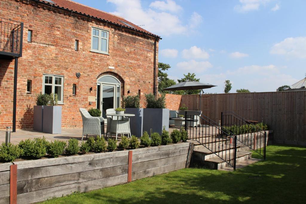 a garden with a table and chairs and a building at The Old Granary in Barnetby le Wold