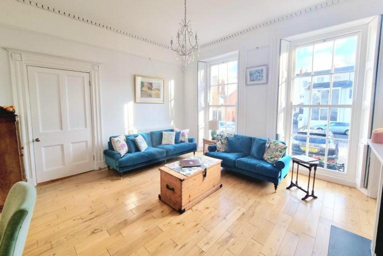 a living room with blue couches and a coffee table at 39 Rodney House in Cheltenham