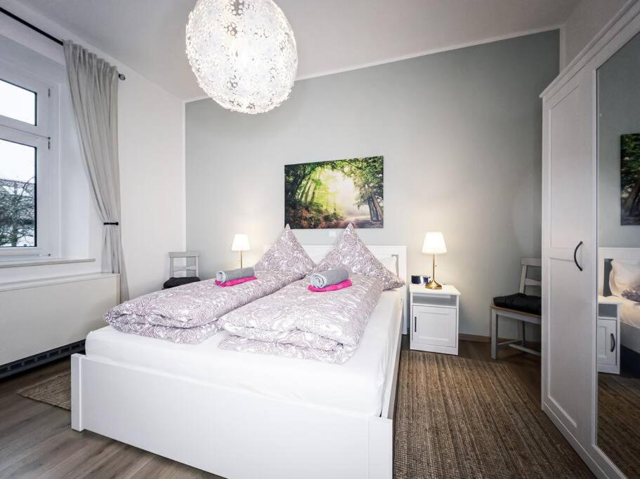 a white bedroom with a large white bed with pink pillows at ►Top Wohnung Nähe Porsche, Flughafen, Messe & BMW◄ in Leipzig