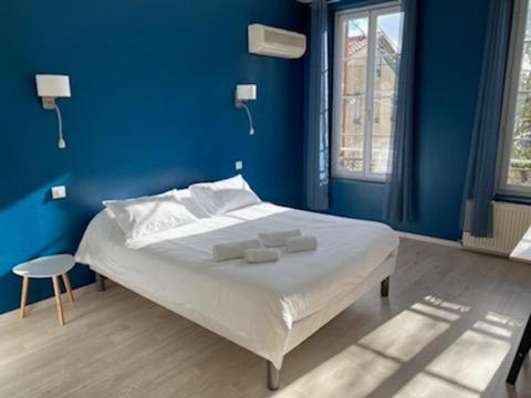 ein blaues Schlafzimmer mit einem Bett mit zwei Handtüchern darauf in der Unterkunft Relais des Iles chambres d'hôtes in Agen