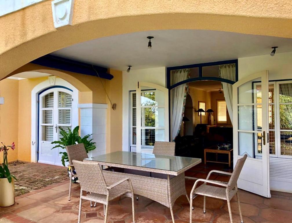 a patio with a table and chairs on a porch at 19 MONTEGO BAY CARIBBEAN Estate in Port Edward